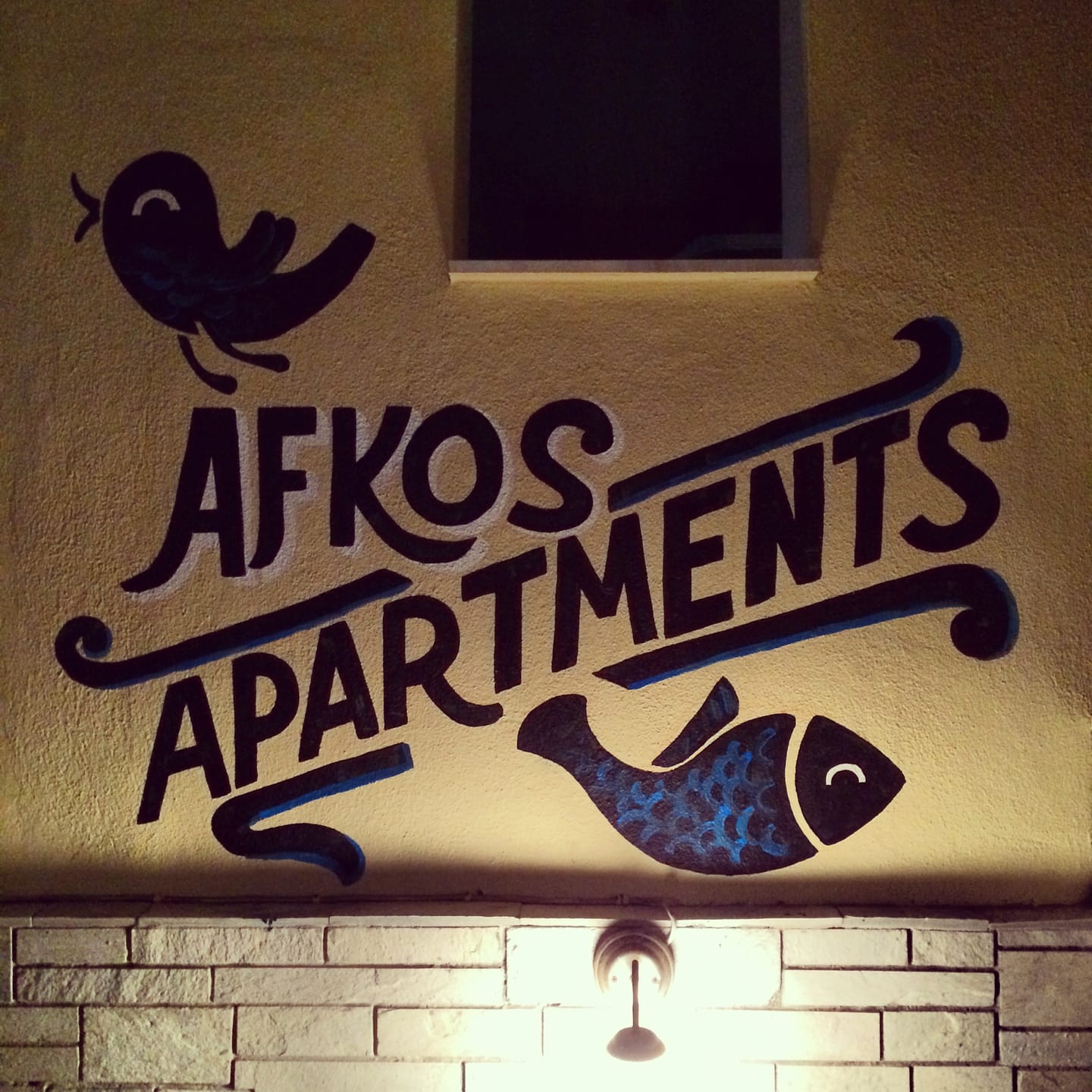 Ζωγραφιστή πινακίδα Afkos Apartments με ψάρι