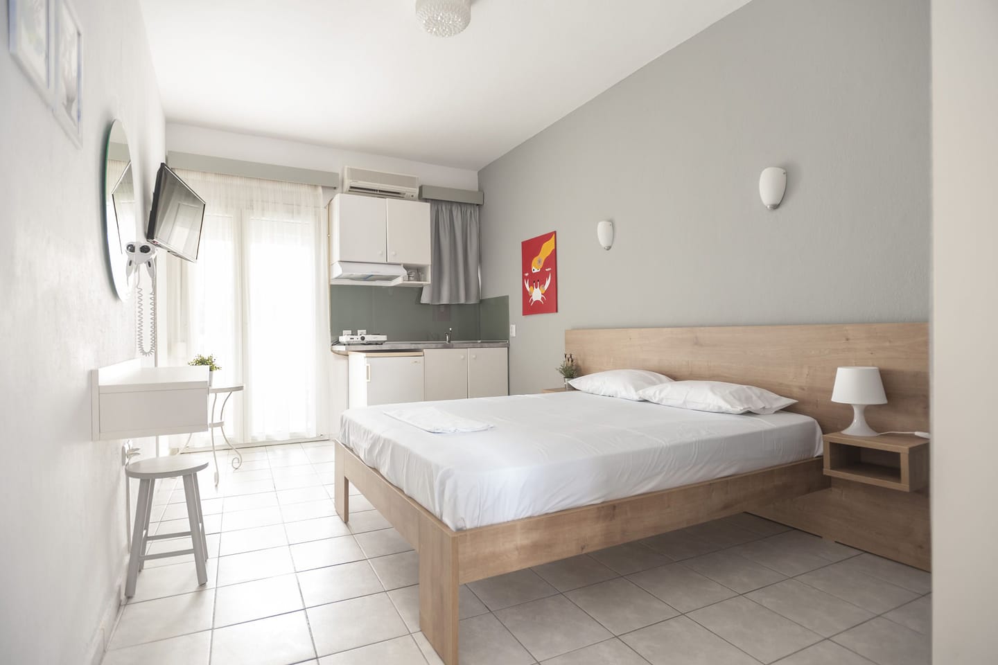 Studio with double bed, kitchenette and red artwork